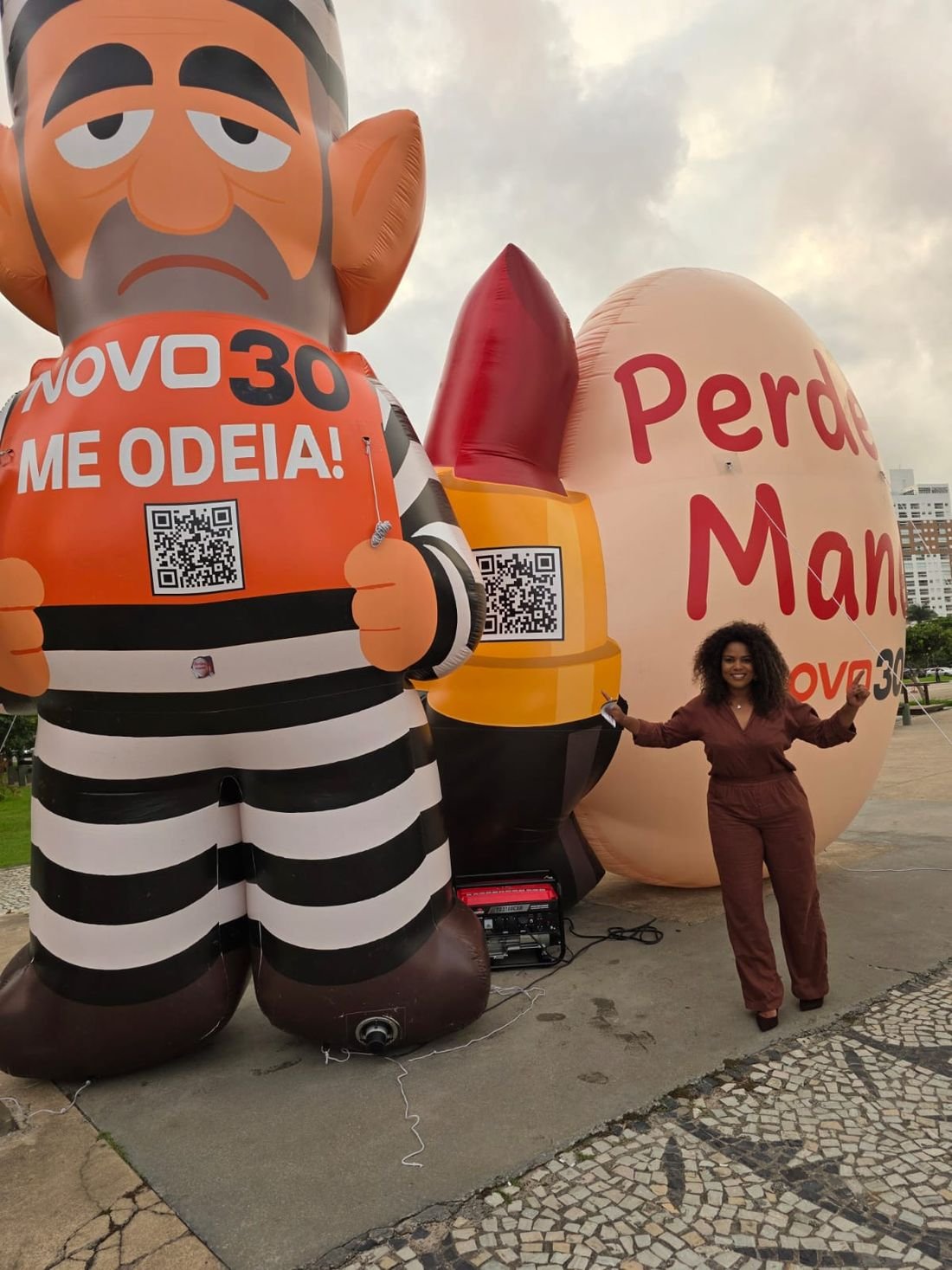 Barbara Kogos ao lado dos infláveis do NOVO em ato na orla